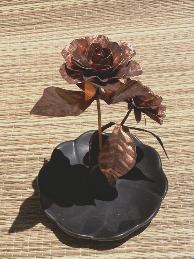 Beautiful copper  'orange' roses with  leaf on ceramic base