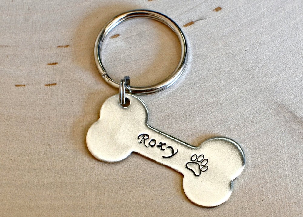 Silver bone shaped dog tag with name and phone number made from solid sterling