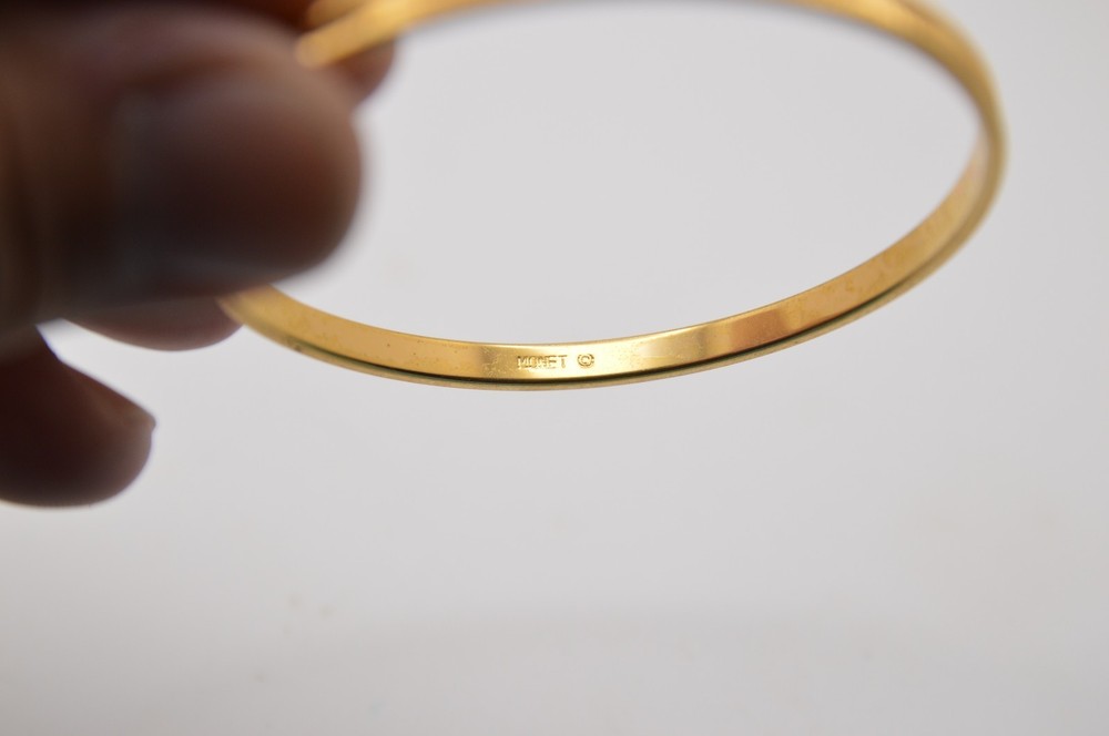Thin gold bangle bracelet, signed Monet, 163