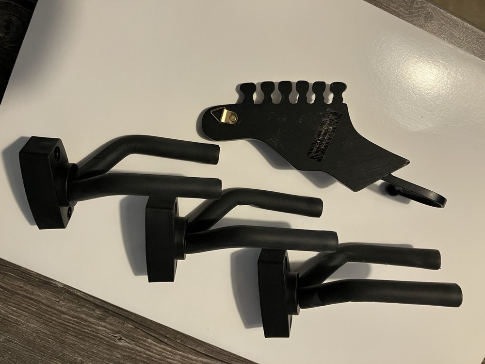 Three guitar wall hangers plus guitar hook
