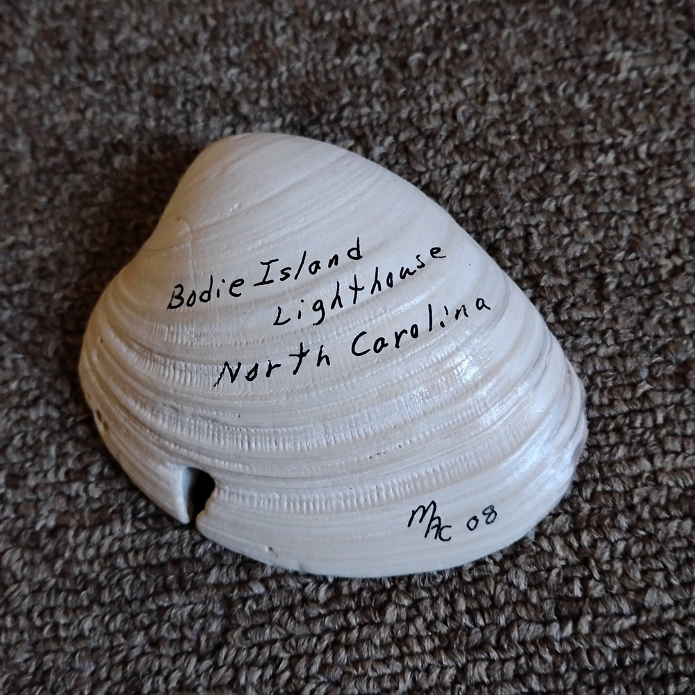 hand-painted seashell featuring a lighthouse scene
