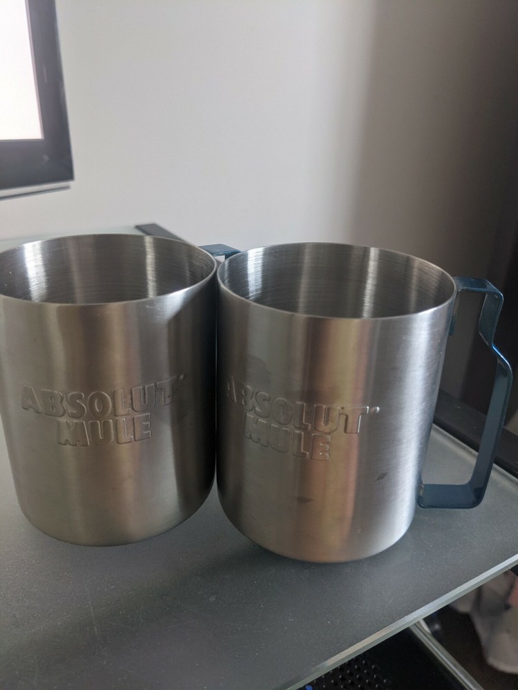 Two stainless absolute mule vodka glasses with blue metal handle