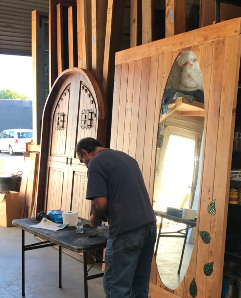 Rustic reclaimed lumber arch top door in square frame solid wood side lites