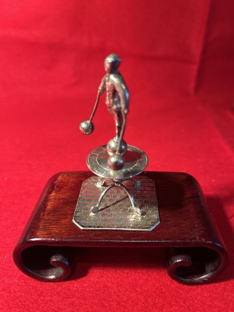 silver miniature man standing on sun dial man roates