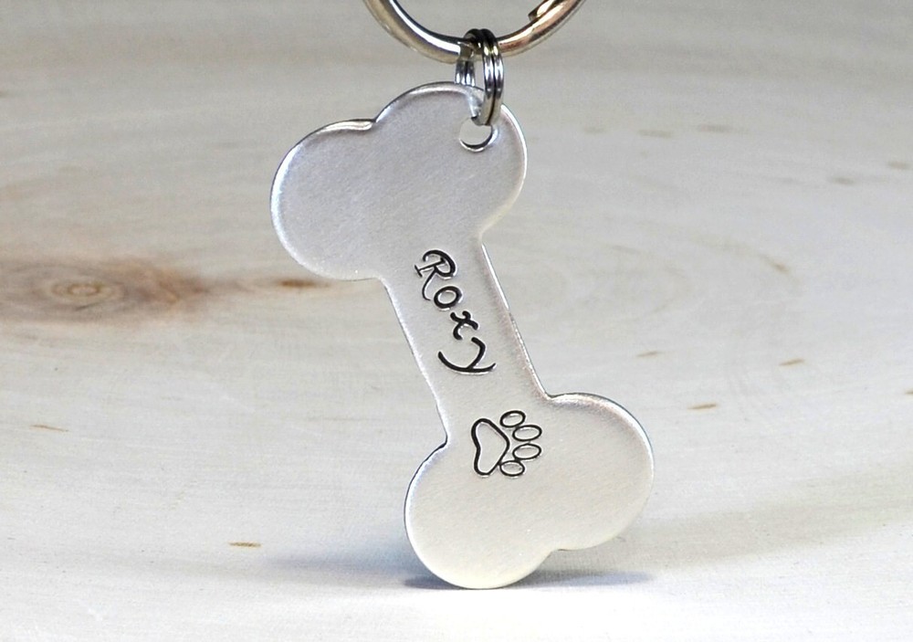 Silver bone shaped dog tag with name and phone number made from solid sterling