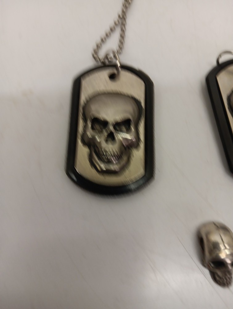 Two Driven Skull Dog Tags And Miniature Skull