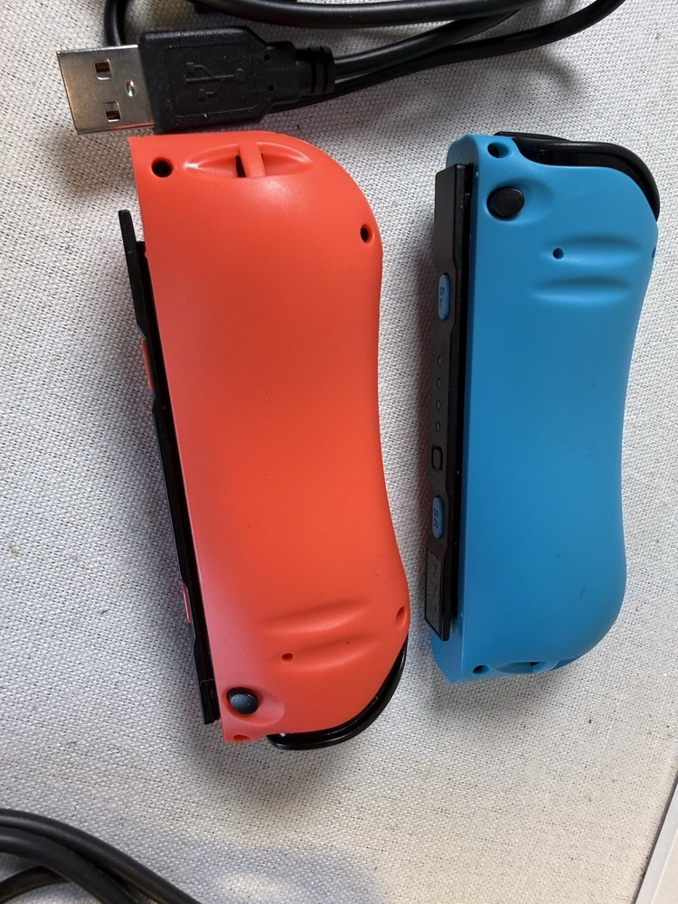 Nintendo Switch Joy-Con controllers accompanied by black USB-C charging cables.