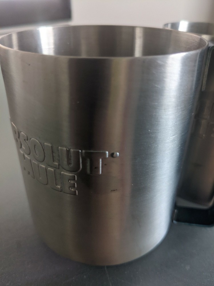 Two stainless absolute mule vodka glasses with blue metal handle