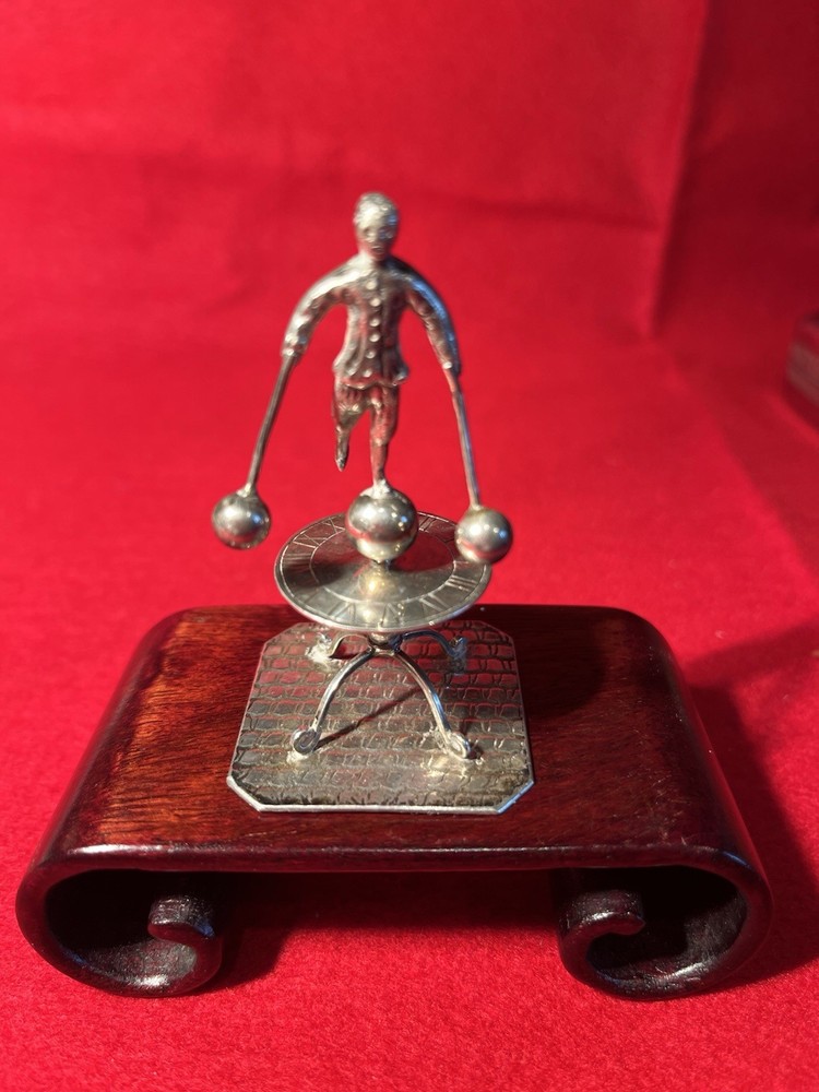 silver miniature man standing on sun dial man roates