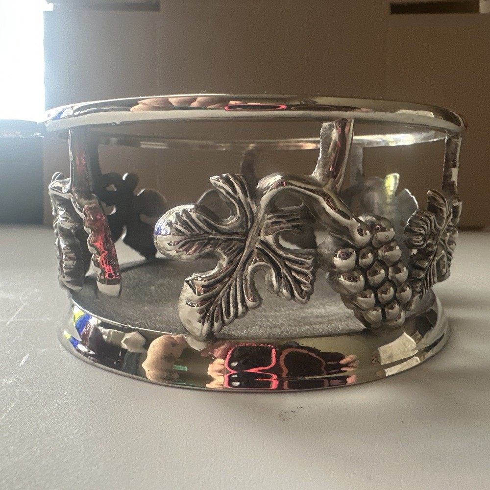 vintage, silver-plated wine bottle coaster featuring intricate grapevine pattern