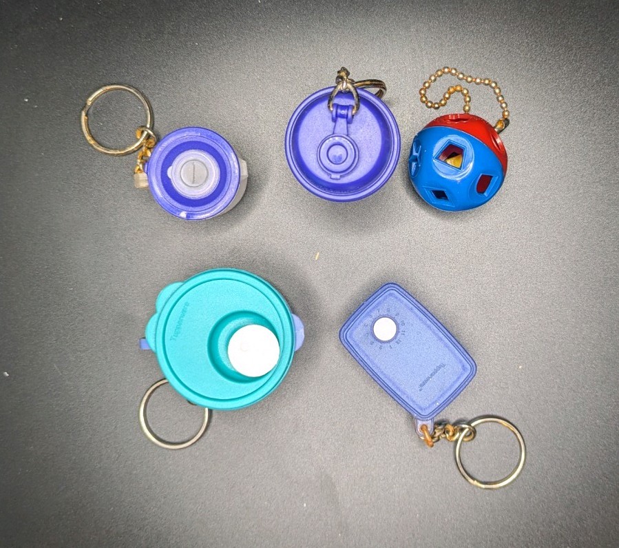 5 miniature Tupperware keychains with removable lids