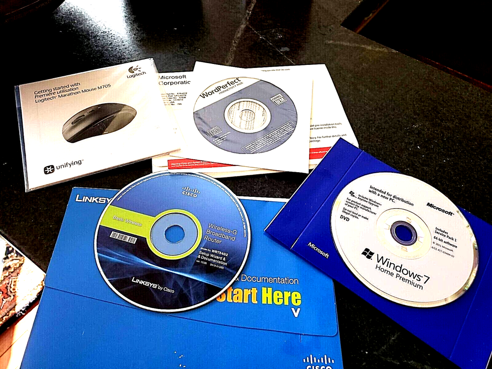 Assorted Software CDs & Logitech Manual (Windows 7, Word Perfect & Linksys)