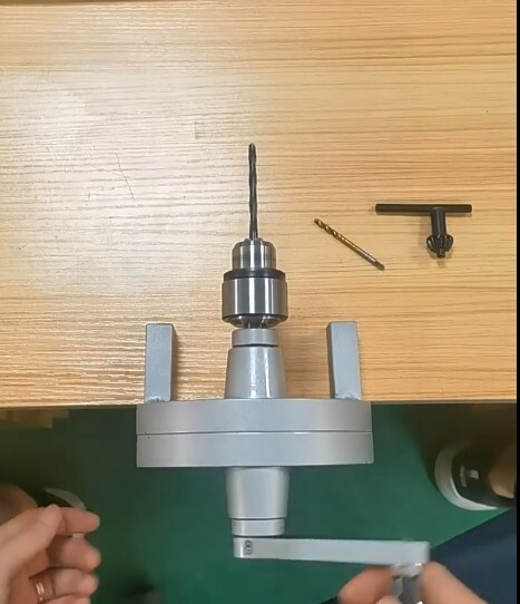 Manual tapping machine includes chuck and hand cranked tapping machine