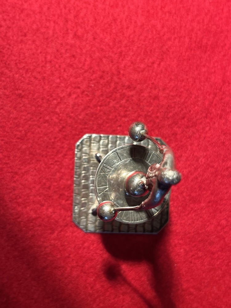 silver miniature man standing on sun dial man roates