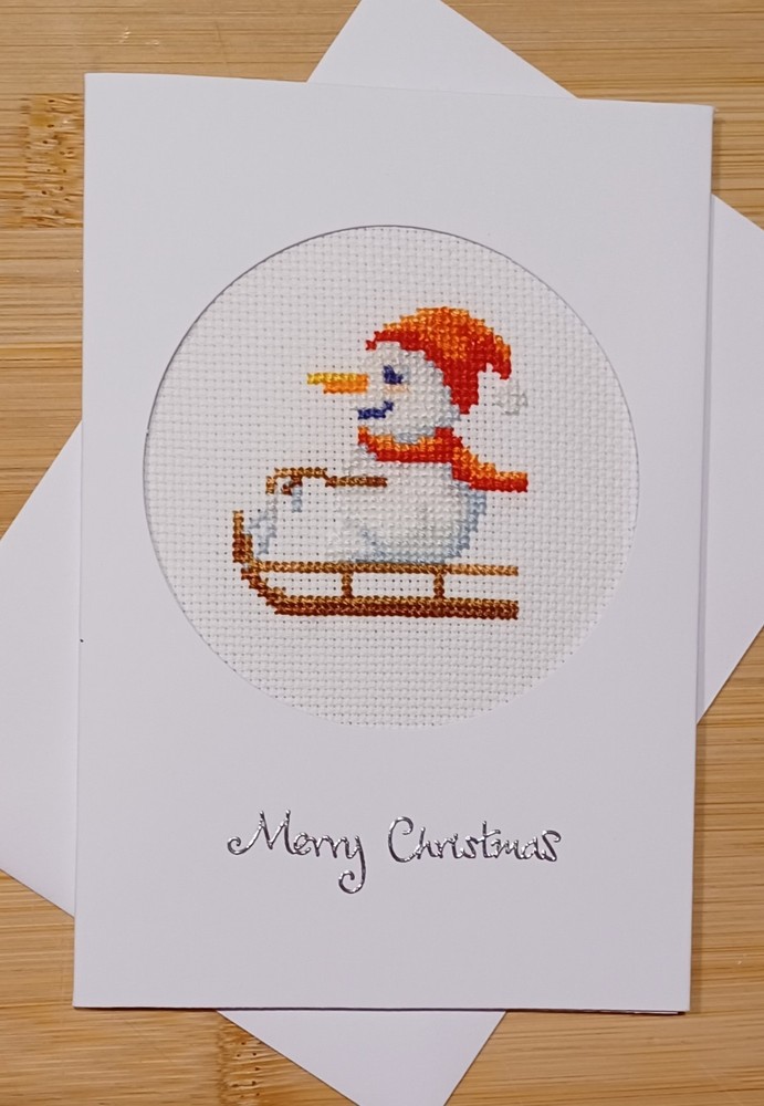 Snowman sledding. Finished Xstitch White card, blank insert & envelope