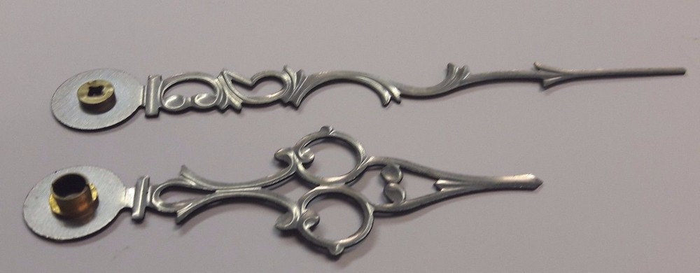 A PAIR OF SMALL STYLISH EMBOSSED CLOCK HANDS.