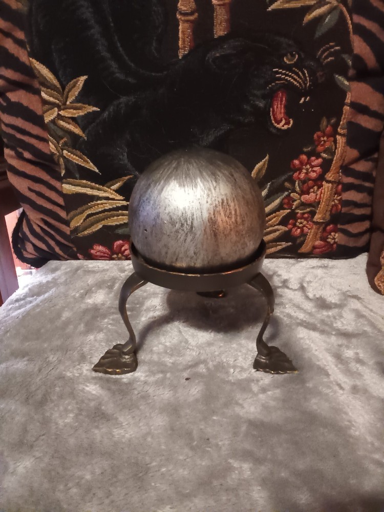 Brushed silver ball,or orb on painted brass base.