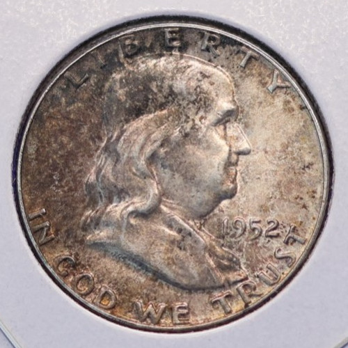 1952 About Uncirculated toned 90% silver Franklin half dollar.