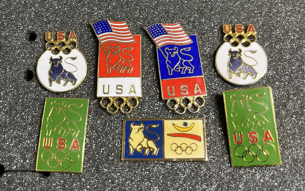 SEVEN (7) ASSORTED OLYMPICS PINS MERRILL  LYNCH BULL
