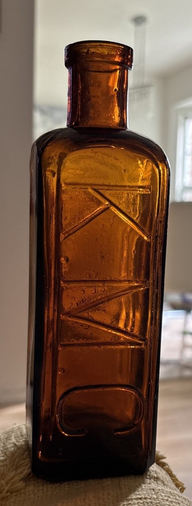 8” Antique K.M.C. Amber Embossed Square Bottle Hand Blown