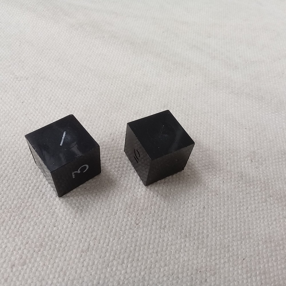 Gamescience dice, d6, pair, black, slanted #1, one inked in crayon