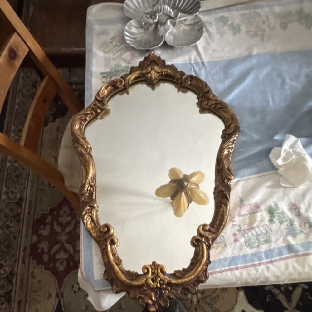 This is a vintage Rococo or Baroque style gilt wall mirror.