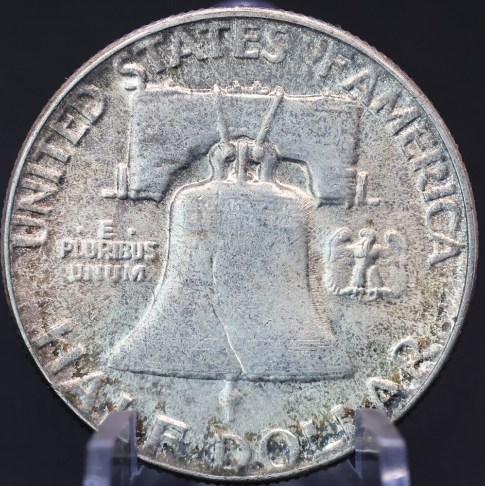 1952 About Uncirculated toned 90% silver Franklin half dollar.