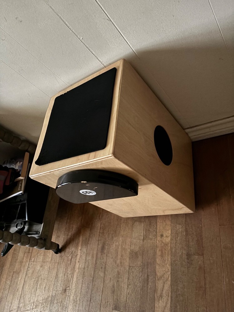 cajon. Light brown wood. Snare built in on side.