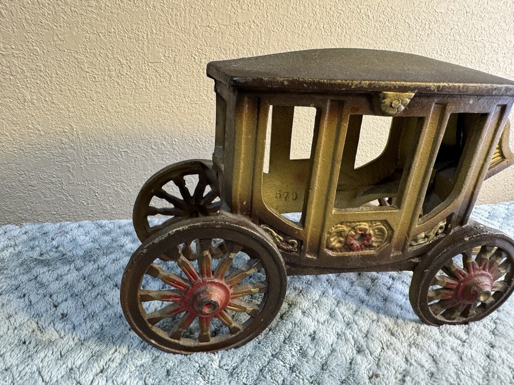 Antique cast iron pull toy carriage with decorative detailing and pull handle