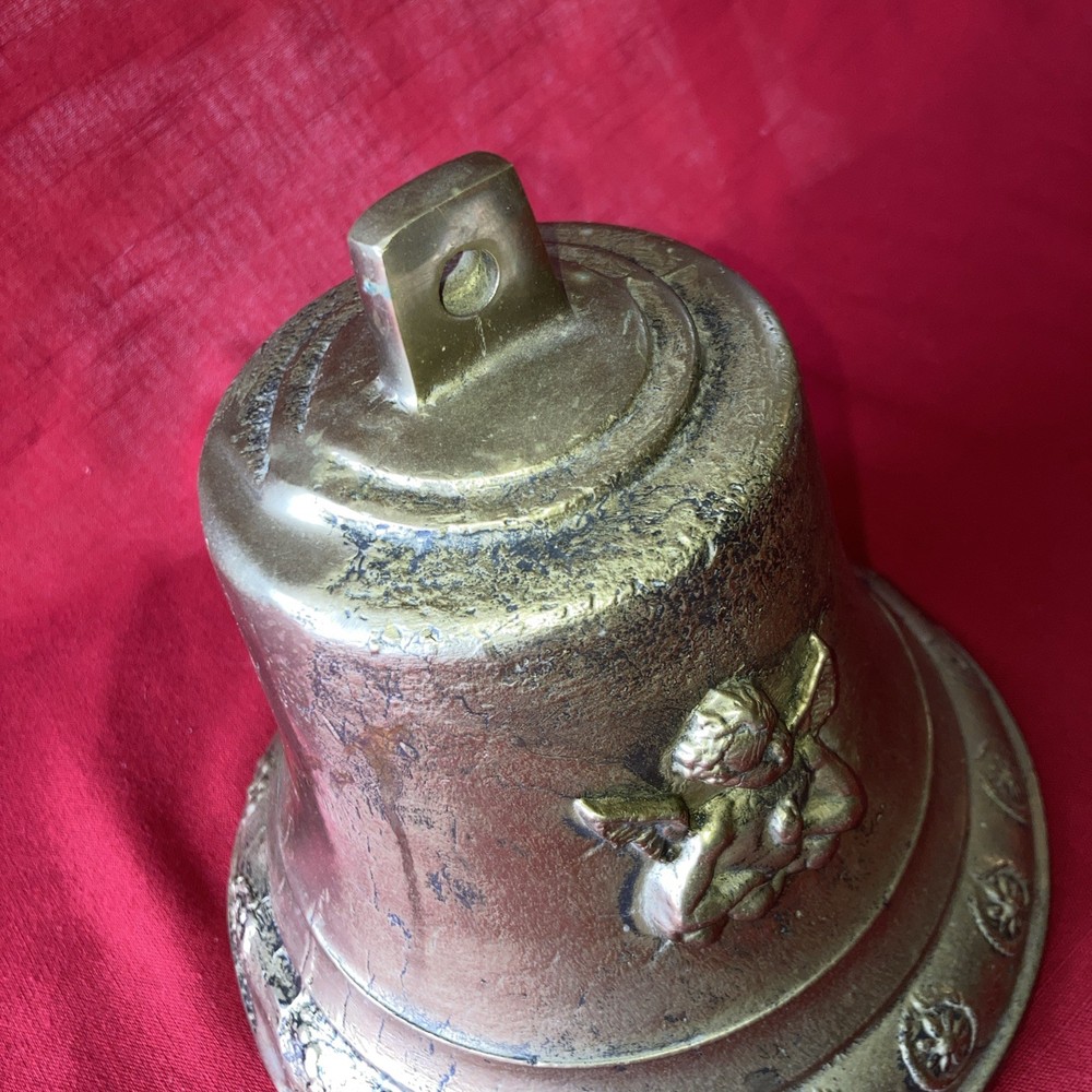 Heavy brass bell with Cupid on each side.