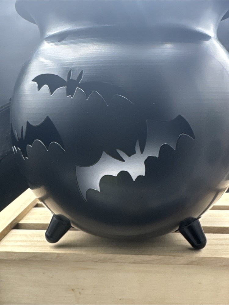 Metal Cauldron Has Bats Cut Out .