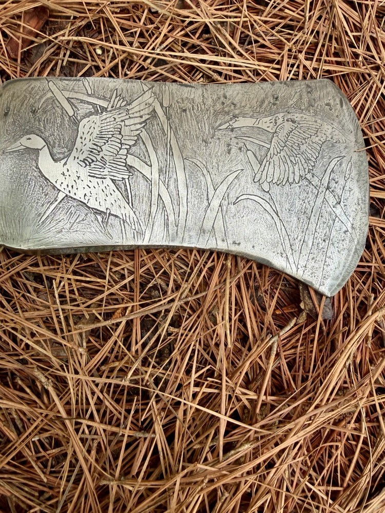 Single Bit Axe With A Duck Scenery Etched On Both Sides.