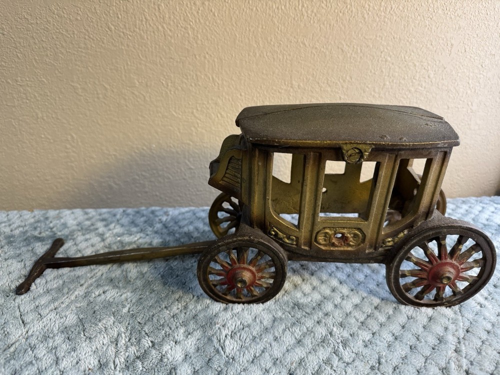 Antique cast iron pull toy carriage with decorative detailing and pull handle