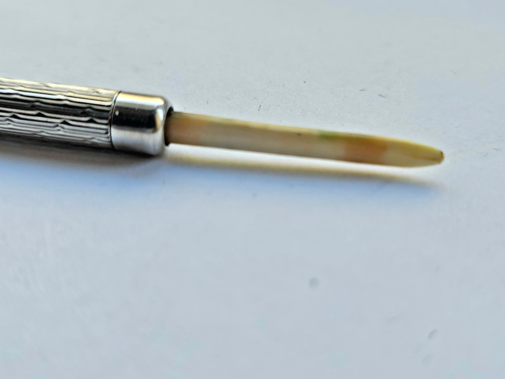 Engine turned silver tooth pick with plastic tool