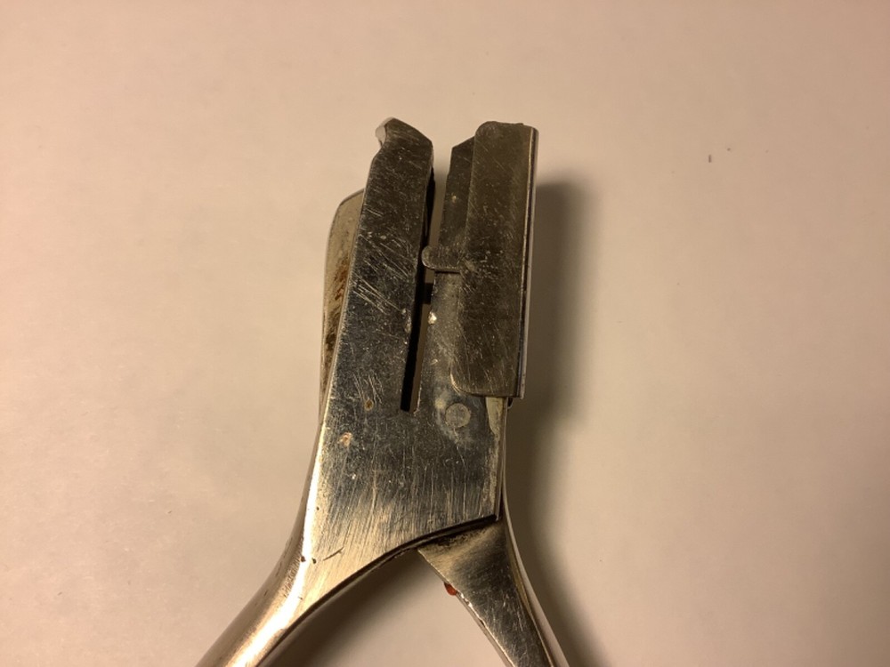 A.F. & Co. hole punch with spring handle action and adjustable punch depth guide