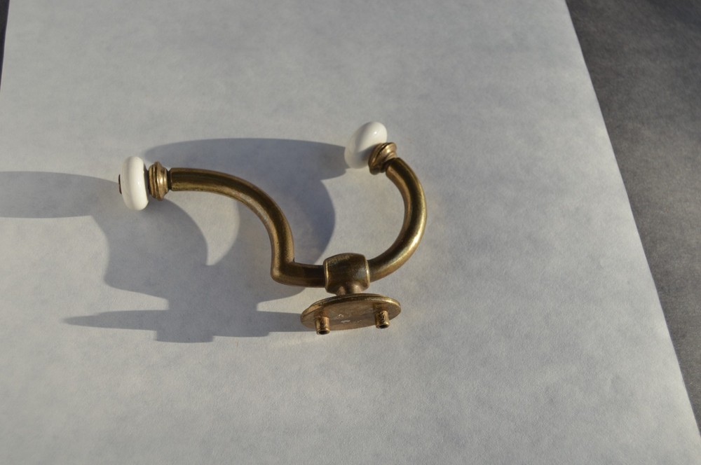 Solid brass with procelain hook that will hold securely is easy to mount .