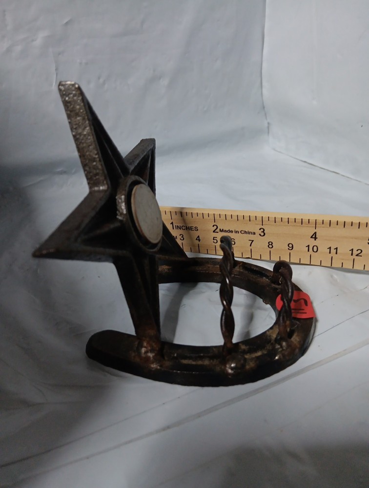 rustic, cast iron desk item featuring a horseshoe base and a large, five-pointed