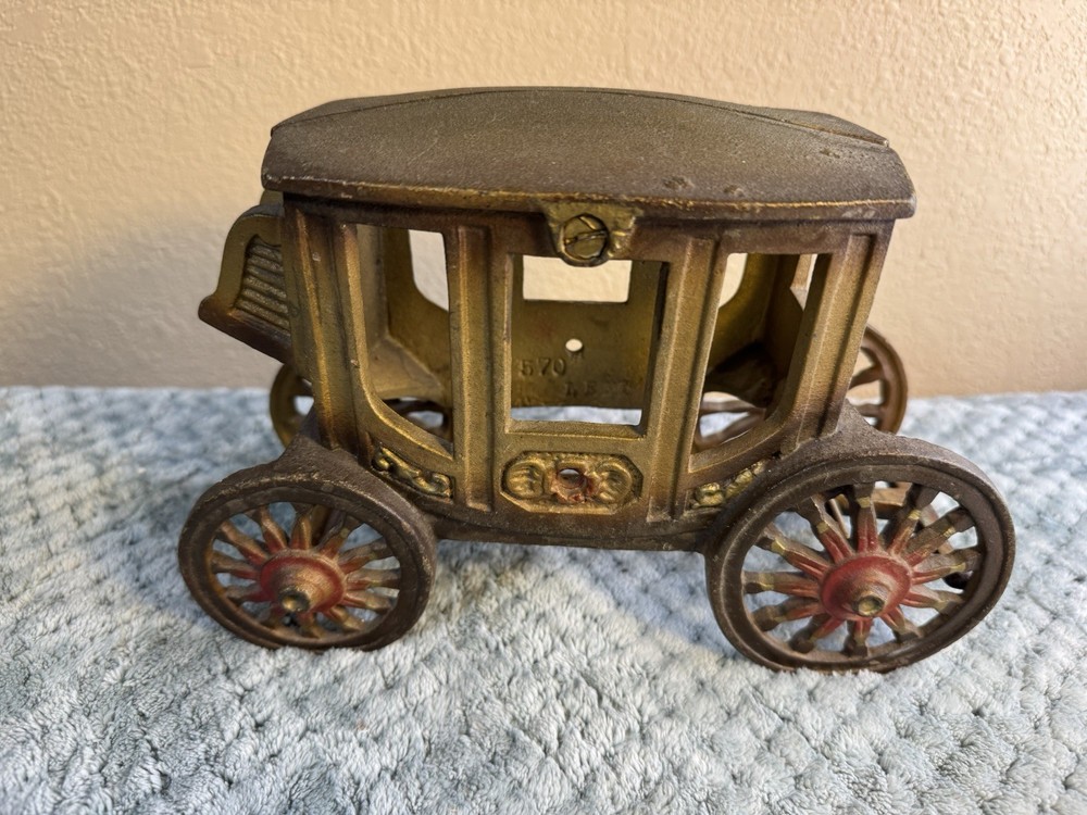 Antique cast iron pull toy carriage with decorative detailing and pull handle