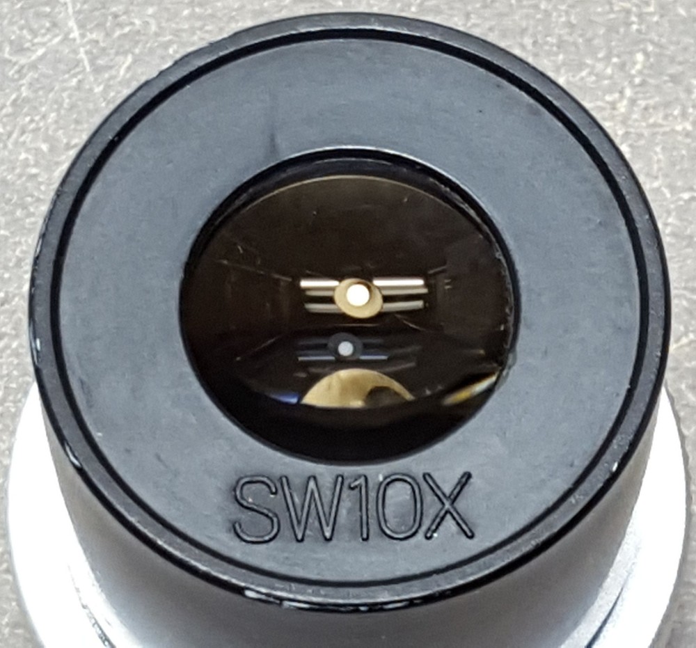 SW10X Microscope Eyepiece. We don’t know what machine it was pulled from.