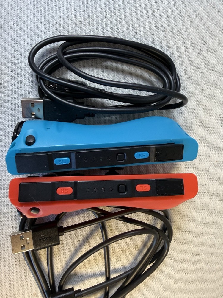Nintendo Switch Joy-Con controllers accompanied by black USB-C charging cables.