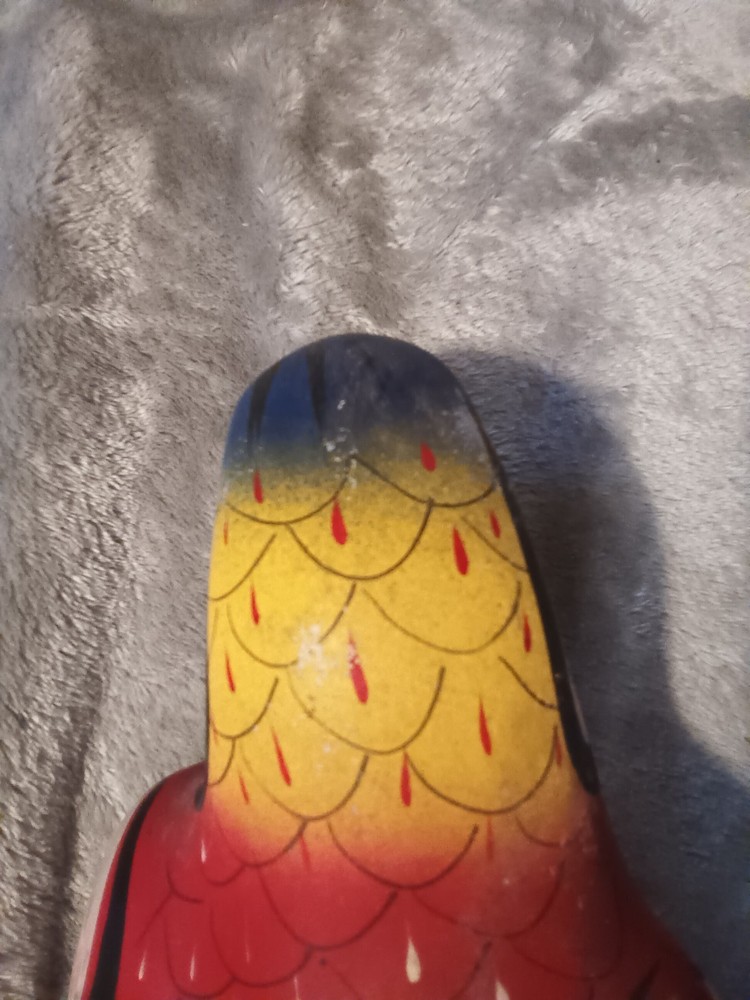 Worn painted ceramic parrot on metal perch,ceiling hanger.