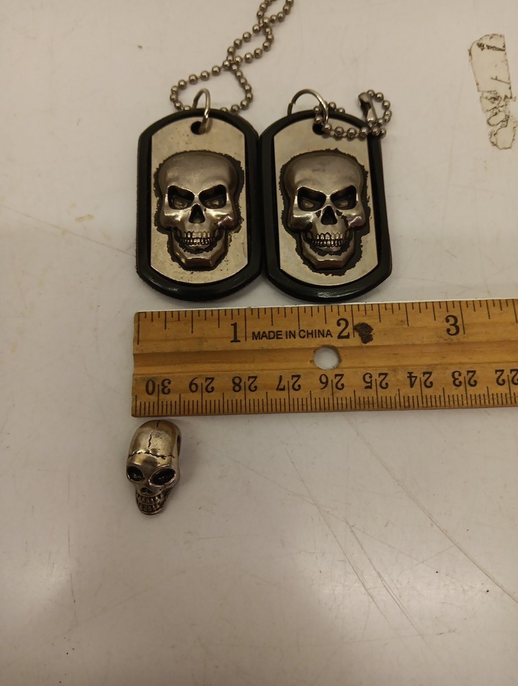 Two Driven Skull Dog Tags And Miniature Skull