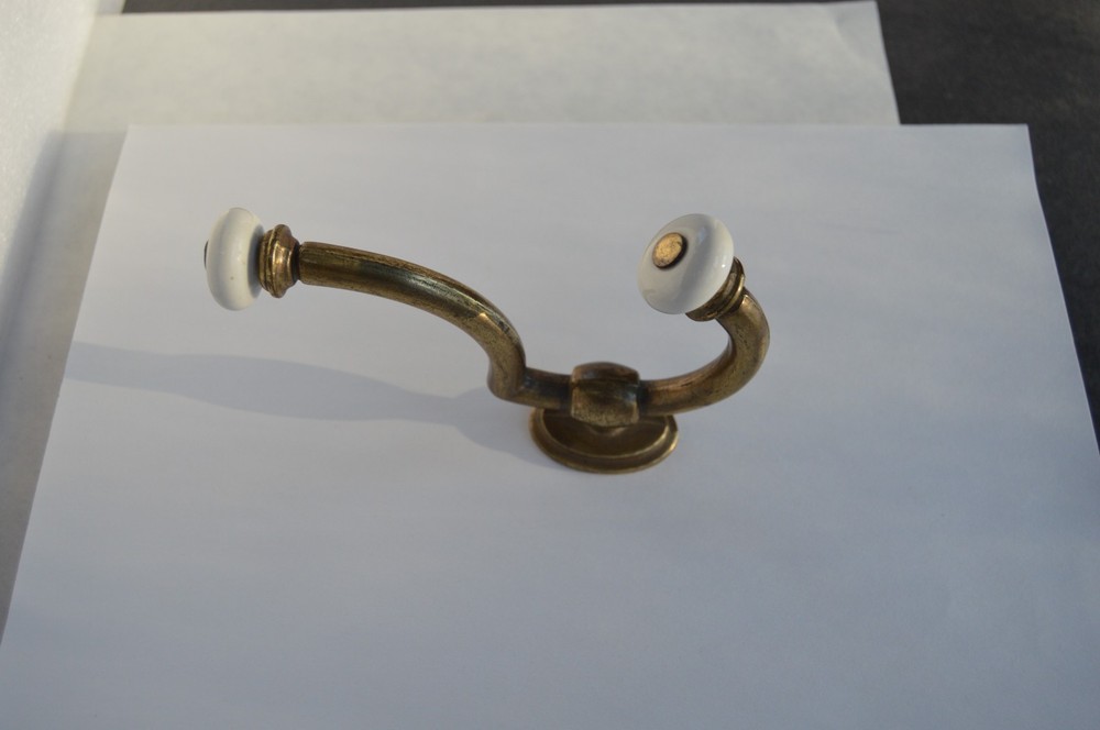 Solid brass with procelain hook that will hold securely is easy to mount .