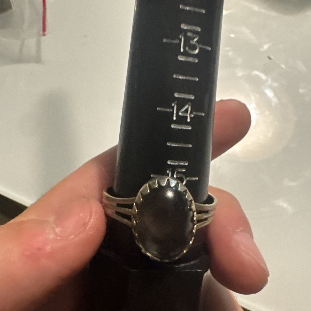 adjustable silver ring with colorless stone on front reflective