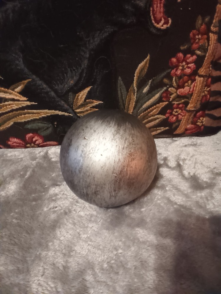 Brushed silver ball,or orb on painted brass base.