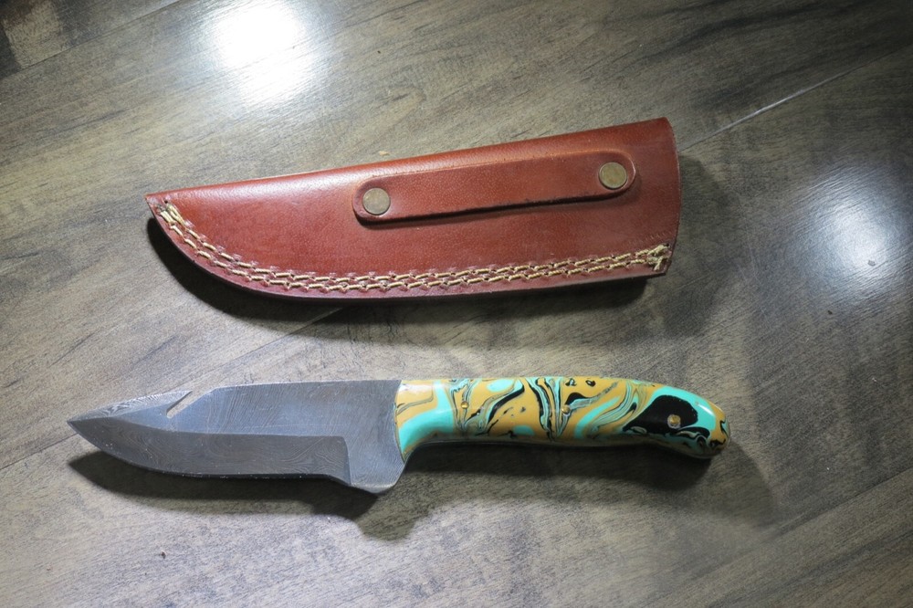 Sleek Damascus knife with multi colored ceramic handle & leather sheath
