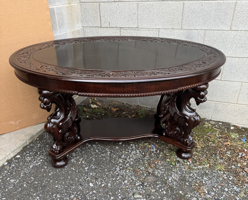 R. J. HORNER CARVED MAHOGANY WING GRIFFIN OVAL LIBRARY TABLE
