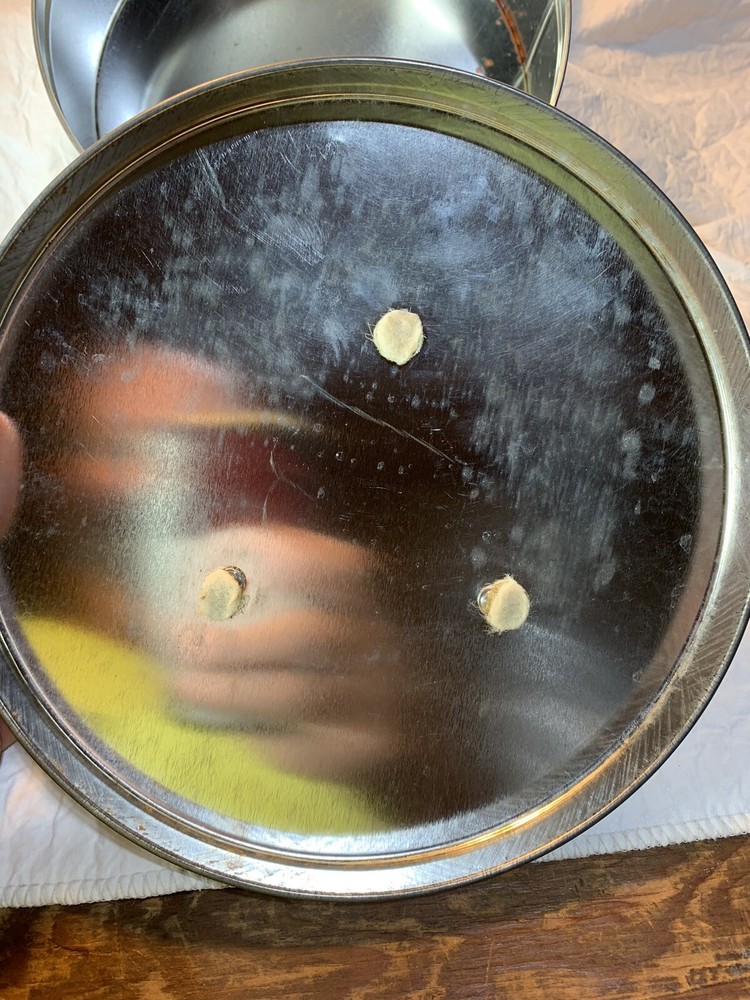 round silver tin with metal golf plaque affixed