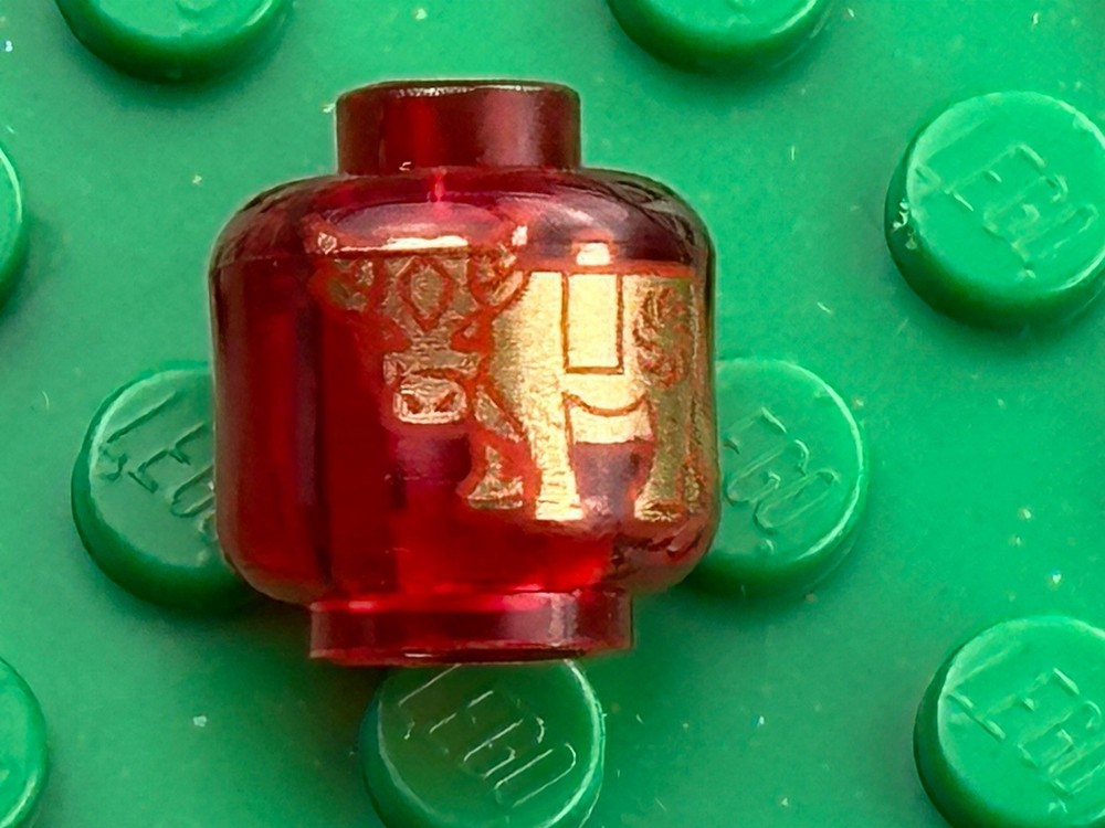 Lego Trans-Red Head With Gold Ox/Bull Pattern