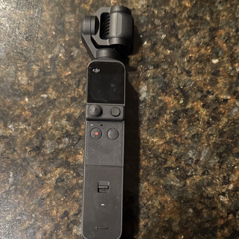 DJI Osmo Pocket 2 with Do it All Handle and tripod attached.